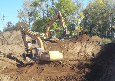 Image of heavy equipment in a pit of dirt digging as part of contaminant remediation