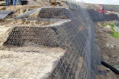 Image of onsite geotechnical engineering with workers assessing process and large equipment onsite.