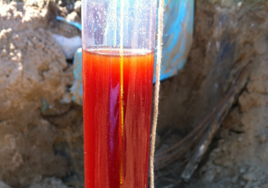 Image of tube with red liquid at a contaminated site.