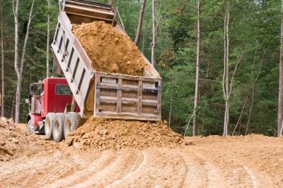 Dump truck moving soil in the field.