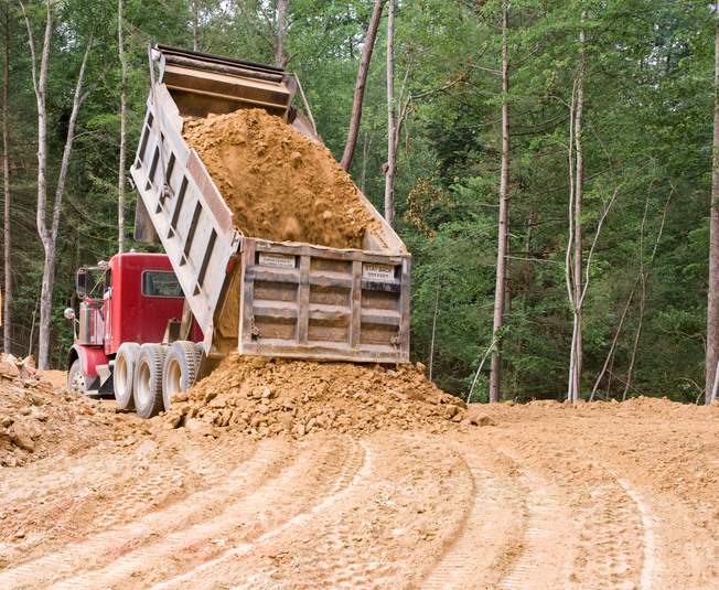 Dump truck moving soil in the field.