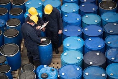 Group of men working at a chemical warehouse classifying barrels for Decommissioning