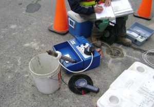 Environmental Site Assessments, image of worker using equipment and completing forms.