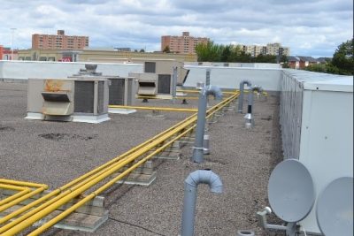 Image of a flat roof with pipes and satellite dishes.