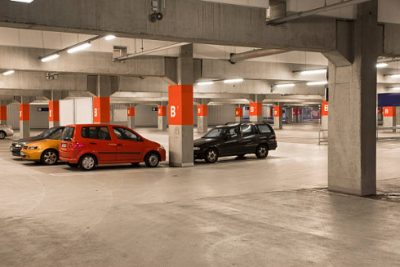 Image of an indoor parking garage with a few cars.